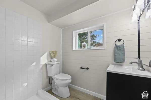 Contemporary bathroom featuring white subway tile walls, a white ceramic toilet, and a black vanity with an integrated white sink basin