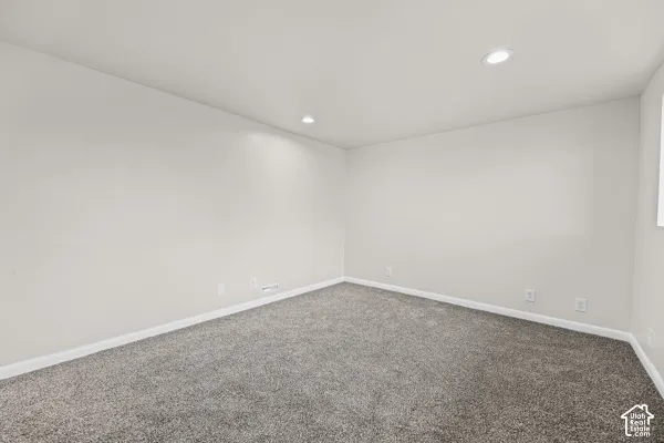 Recessed lighting and neutral wall finishes complement the gray carpeting