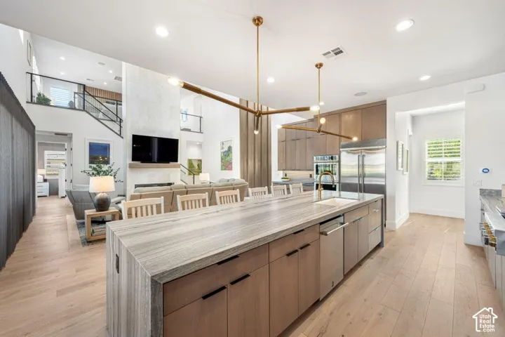 Gourmet kitchen with a large island, integrated stainless steel appliances, and wood cabinetry