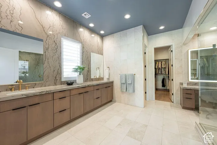 Extended vanity with dual sinks, stone countertop, and wood-finish cabinetry