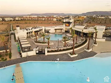 Expansive lagoon with a floating dock, adjacent to a large pool area with multiple lounge spaces