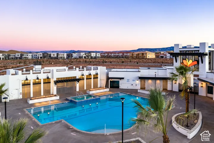 Resort-style pool area featuring a large swimming pool, integrated spa, and multiple fire features