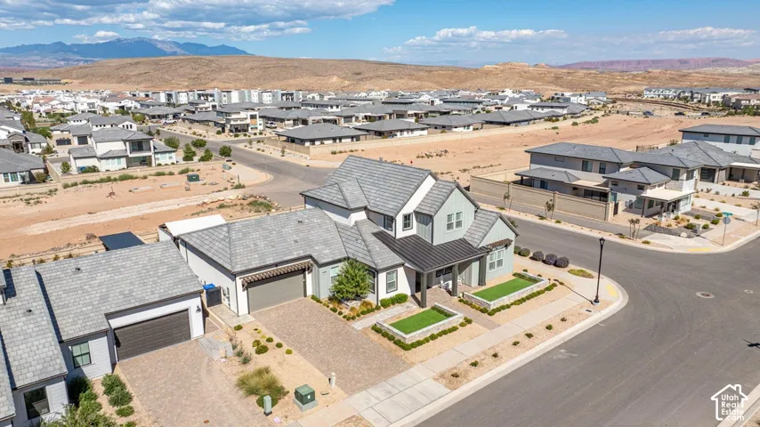Contemporary residential architecture with a light-toned exterior, dark-toned roofing, and a two-car garage