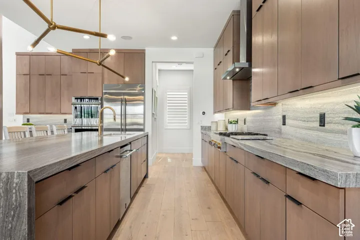 Kitchen featuring wood-finish cabinetry, stainless steel appliances, stone countertops, and recessed lighting