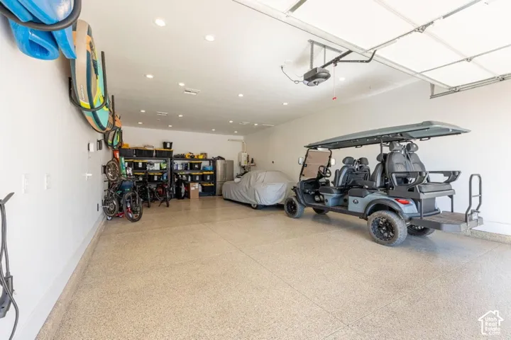 Expansive garage featuring a finished epoxy floor, recessed lighting, and an automatic garage door opener