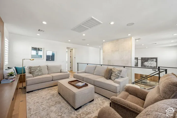Recessed lighting illuminating the area, light wood-finish flooring, and a built-in window bench