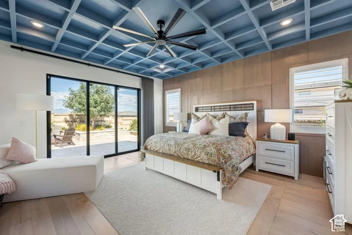 Coffered ceiling with recessed lighting, wood-finish flooring, sliding glass patio door, and wall paneling