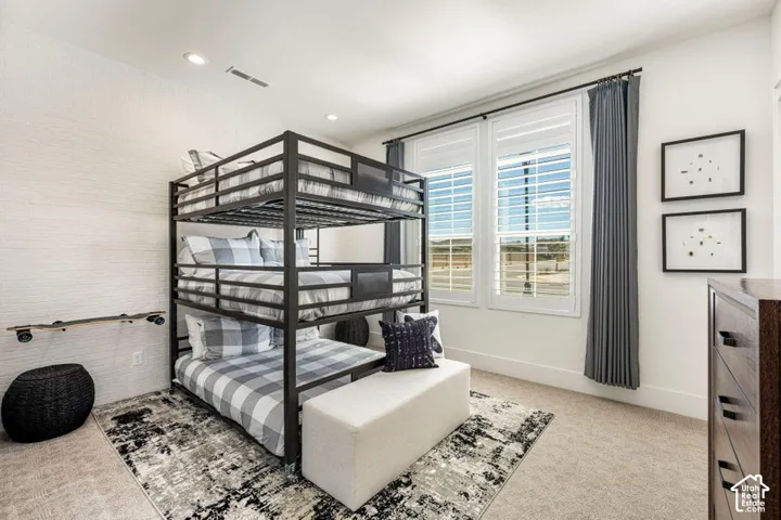 Built-in bunk bed structure, dual windows with plantation shutters, recessed lighting, and wall-to-wall carpeting