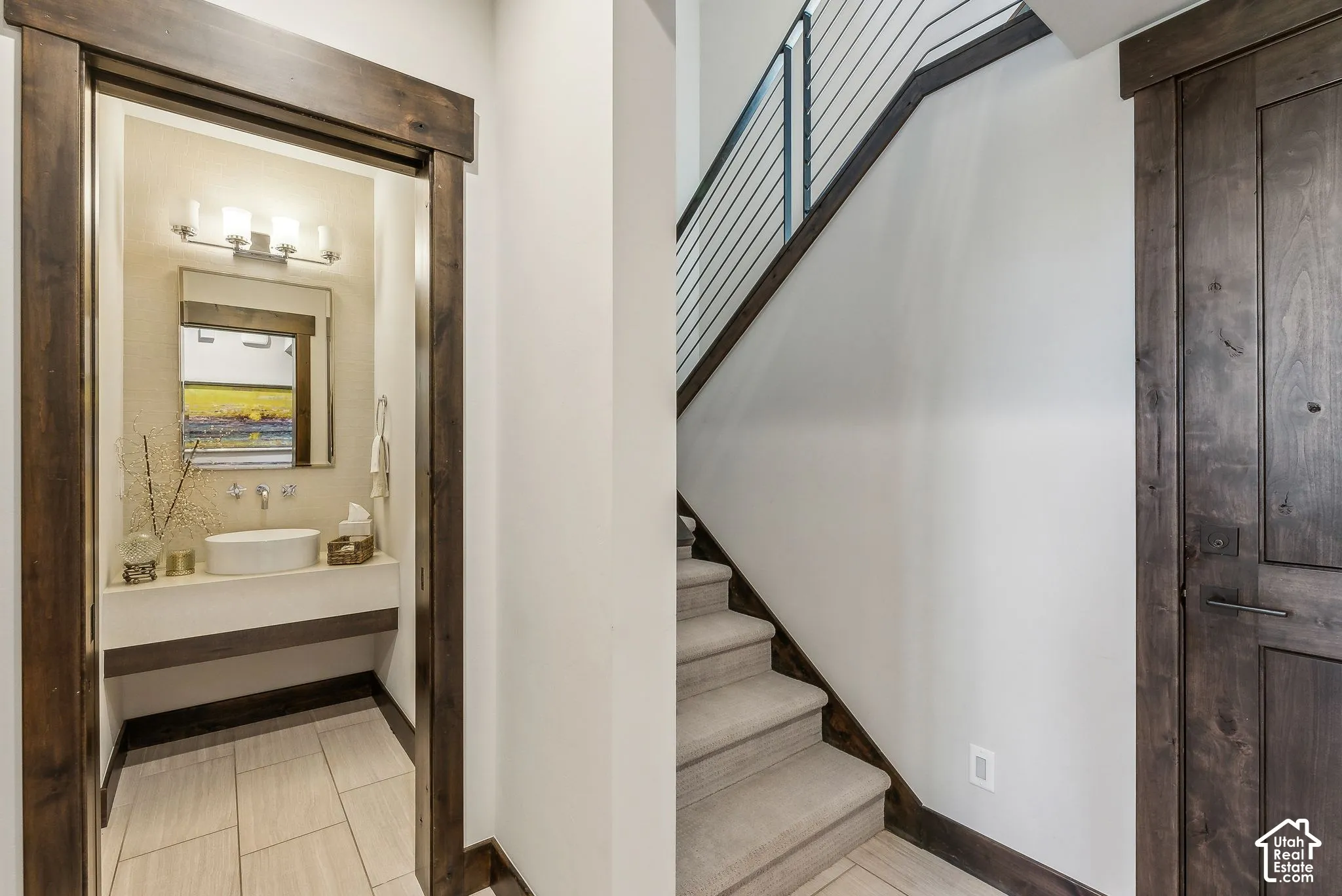 Contemporary hallway and staircase featuring wood-finish treads with metal railings, neutral wall finishes, and recessed lighting