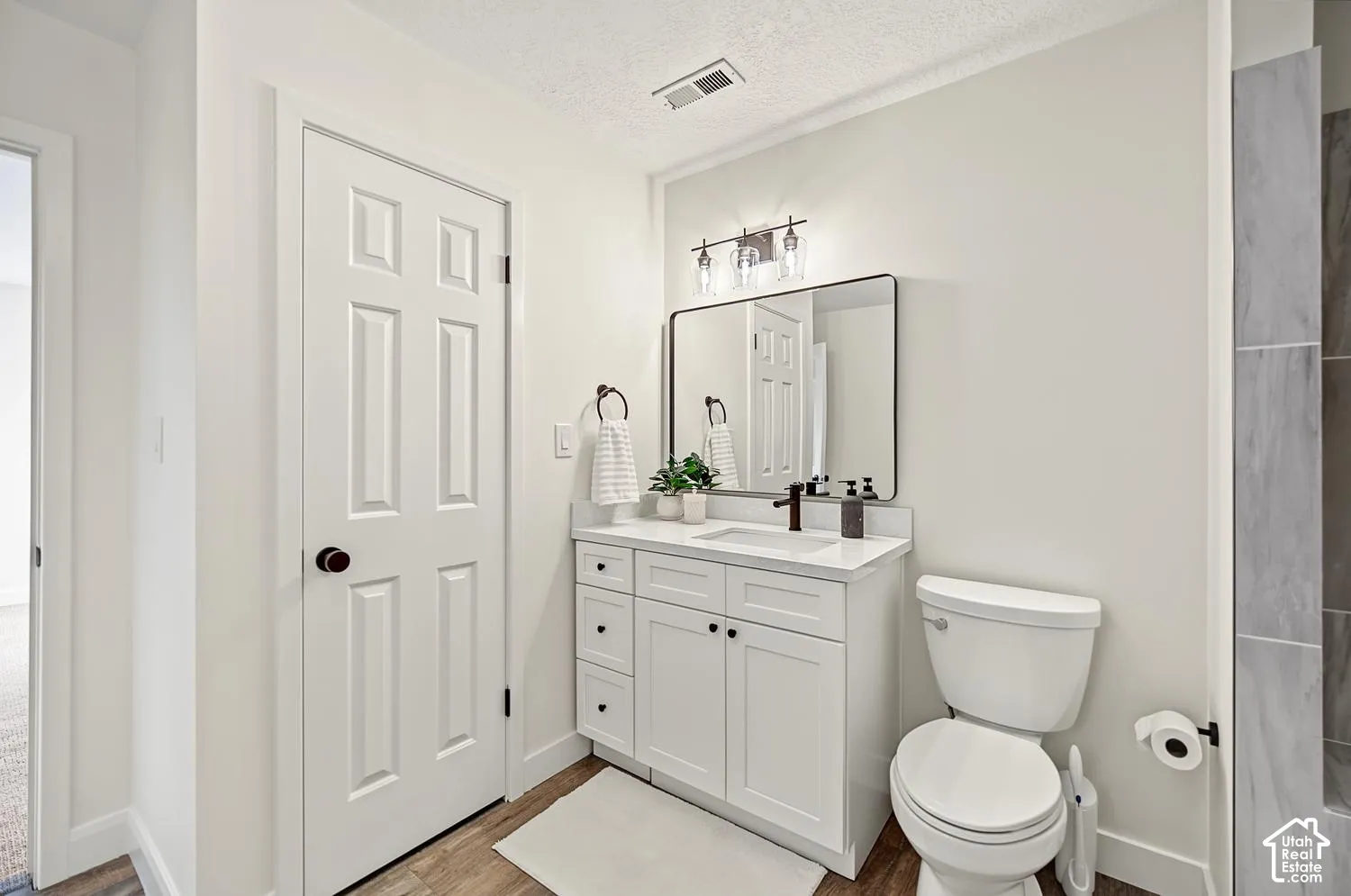 White vanity with a white countertop and rectangular undermount sink