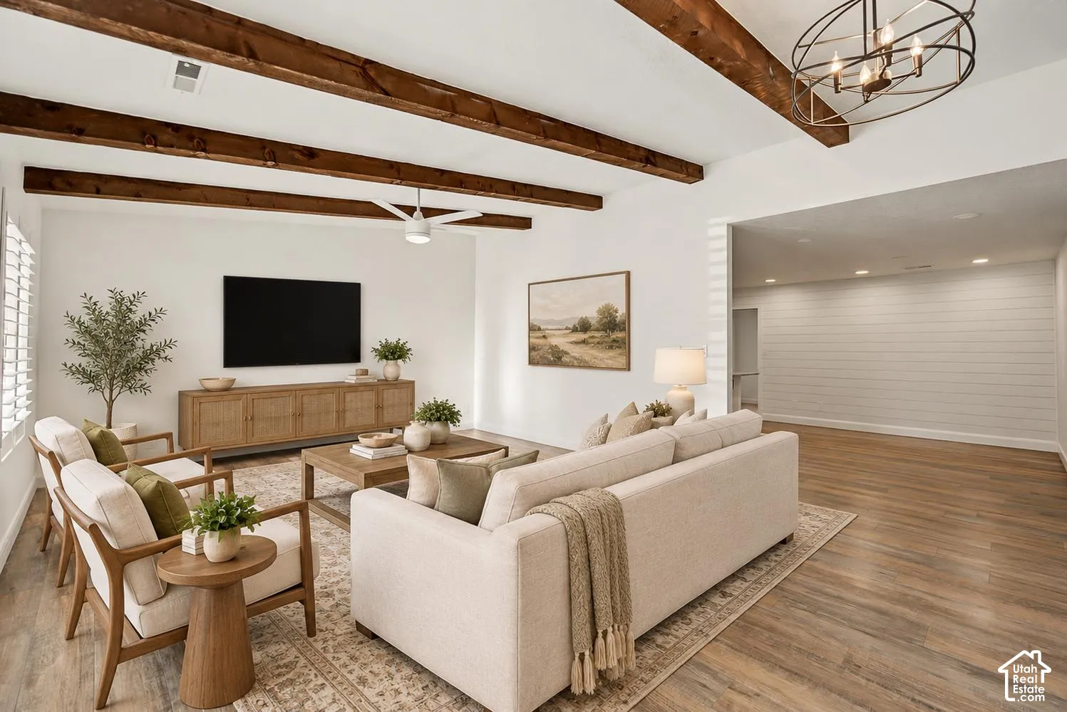 Exposed wood ceiling beams, white shiplap accent wall, wood-finish flooring, recessed lighting, and a contemporary ceiling fan