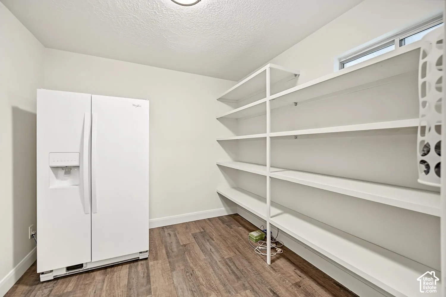 Dedicated pantry room with wood-finish flooring