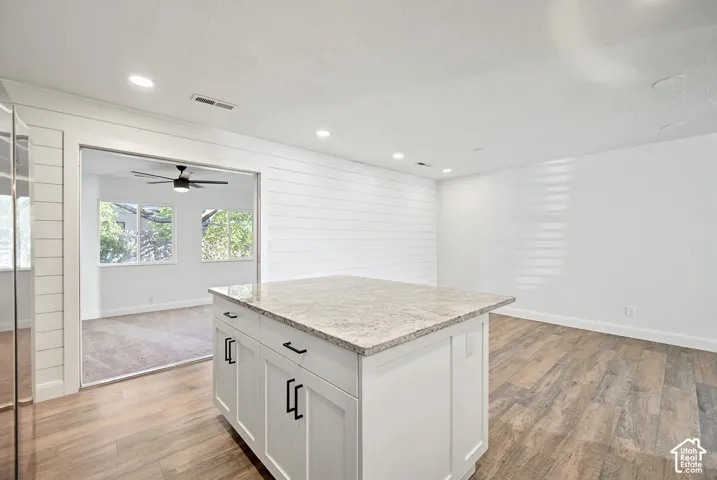 White kitchen island with stone-finish countertop and cabinet storage