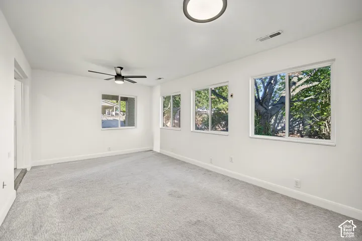 Wall-to-wall carpeting, multiple windows, ceiling fan, and recessed lighting