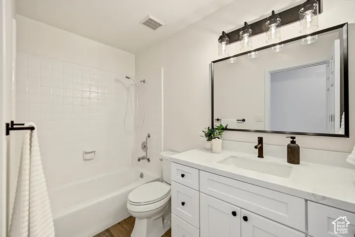 White vanity with under-mount sink, quartz countertop, and dark bronze faucet