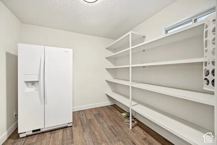 Dedicated pantry room with wood-finish flooring