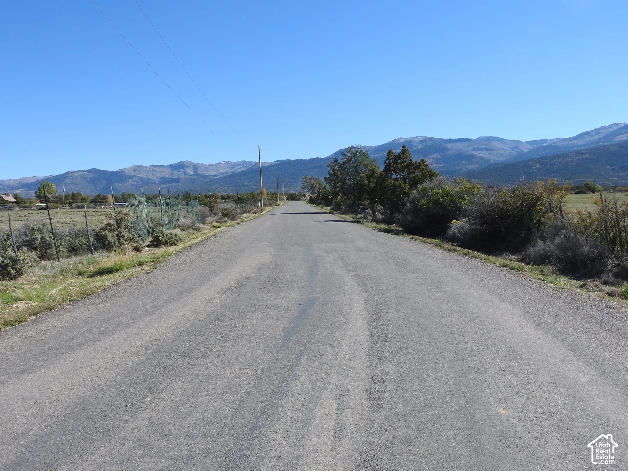 Paved road access with natural landscaping and prominent mountain backdrop