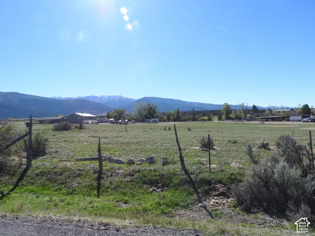 Expansive open land parcel featuring mountain backdrops and wire-post fencing