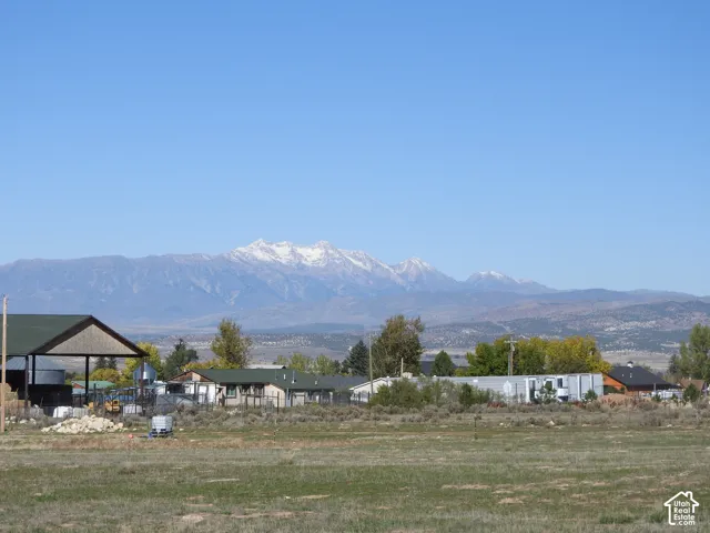 Expansive parcel of land featuring mountain backdrops and a covered open-air structure