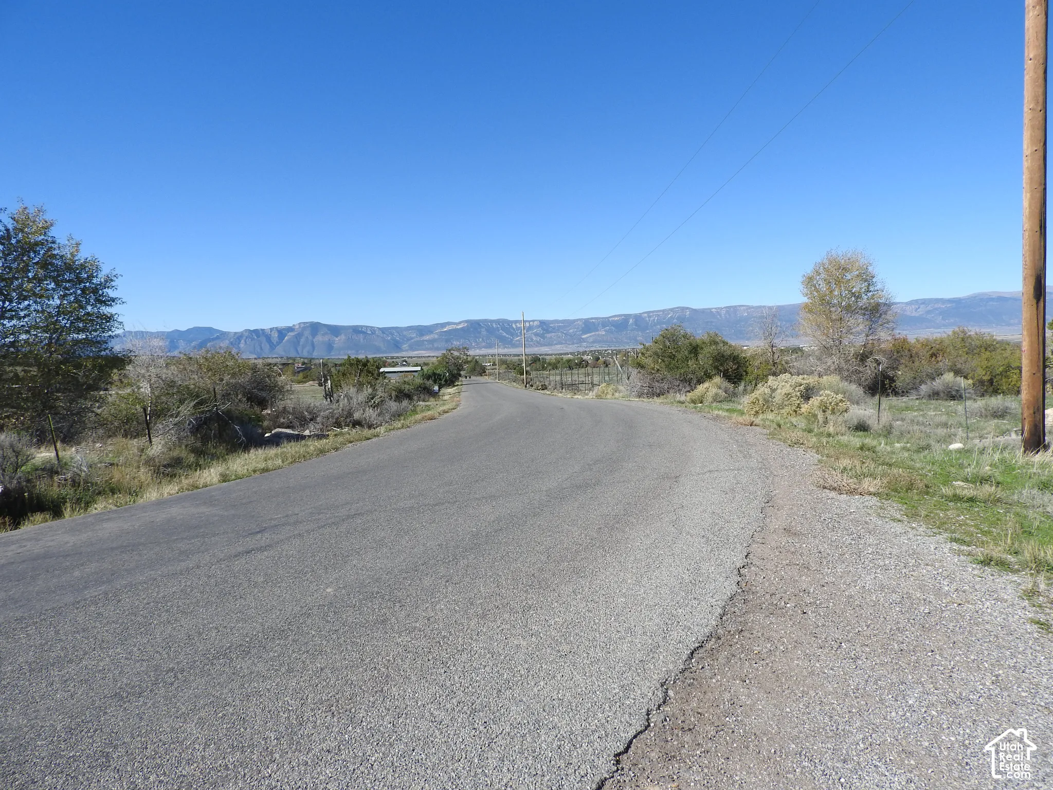 Paved roadway with expansive desert landscape and prominent mountain backdrop