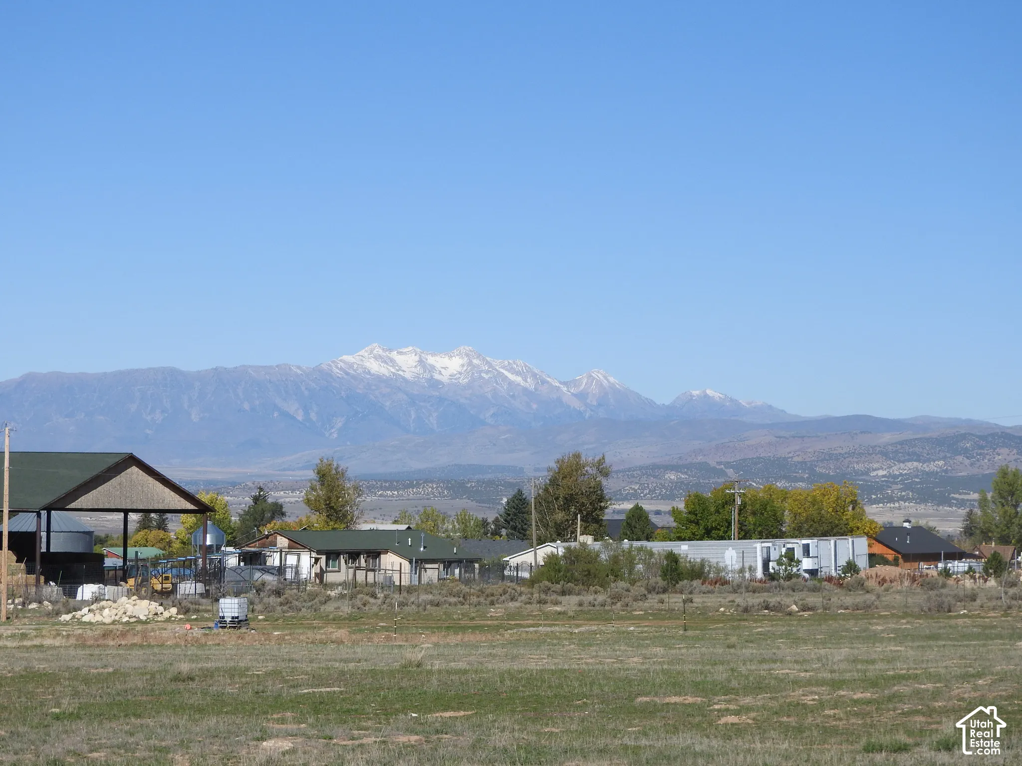 Expansive terrain featuring snow-capped mountain backdrops and a covered outdoor structure