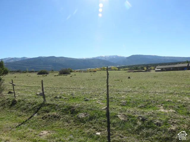 Expansive parcel of land featuring mountain backdrops, open terrain, and wire-and-post perimeter fencing