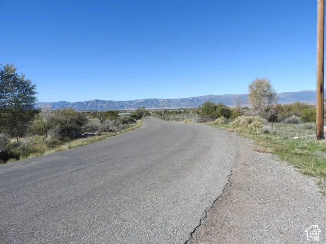 Paved roadway with expansive desert landscape and prominent mountain backdrop