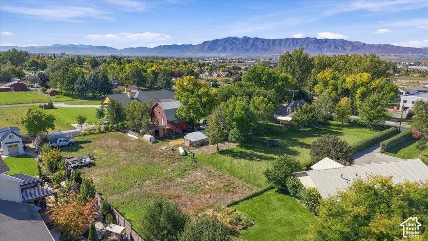 Expansive property featuring a red barn structure, detached garage, and mature trees