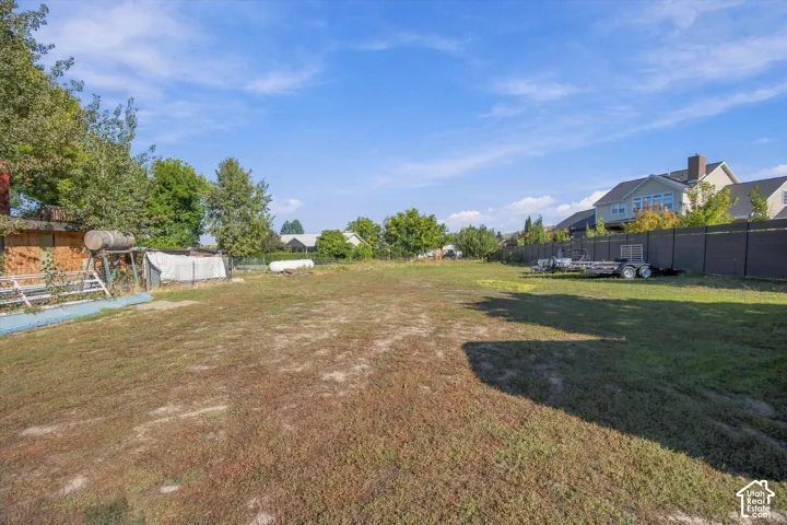 Expansive lot featuring a grassed area and a dark-toned fence