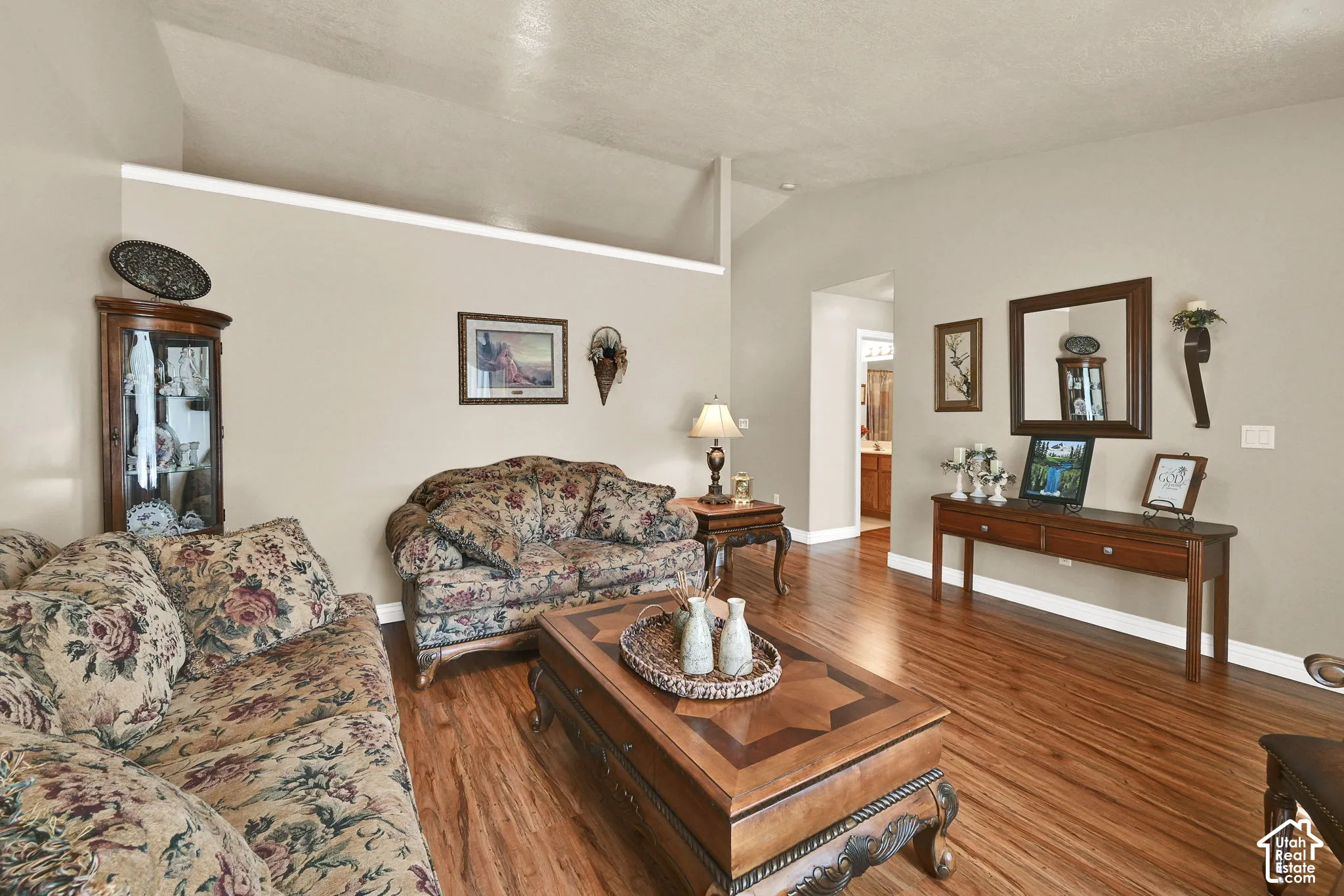 Vaulted ceiling, wood-finish flooring, recessed wall niche, and built-in display cabinet