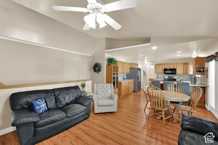 Open-concept living space featuring wood-finish flooring, a ceiling fan, and recessed lighting