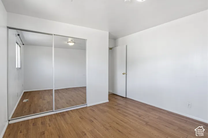 Wood-finish flooring, mirrored sliding closet doors, and recessed ceiling lighting