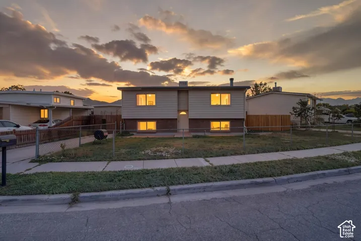 Two-story residence featuring light-colored siding and a brick-finish lower level