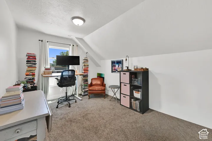 Carpeted room with a window, sloped ceilings, and flush-mount lighting