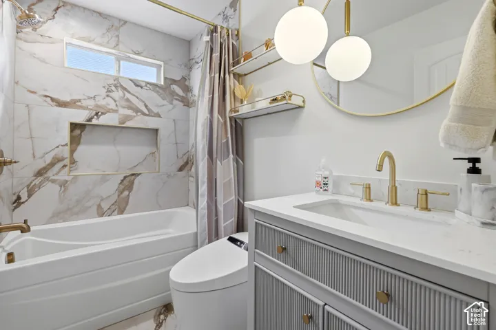 White bathtub with a tiled surround, recessed shower niche, and brass fixtures