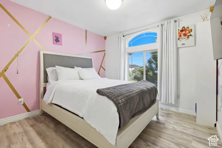 Arch-top window, wood-finish flooring, recessed ceiling lighting, and a feature wall with geometric detailing