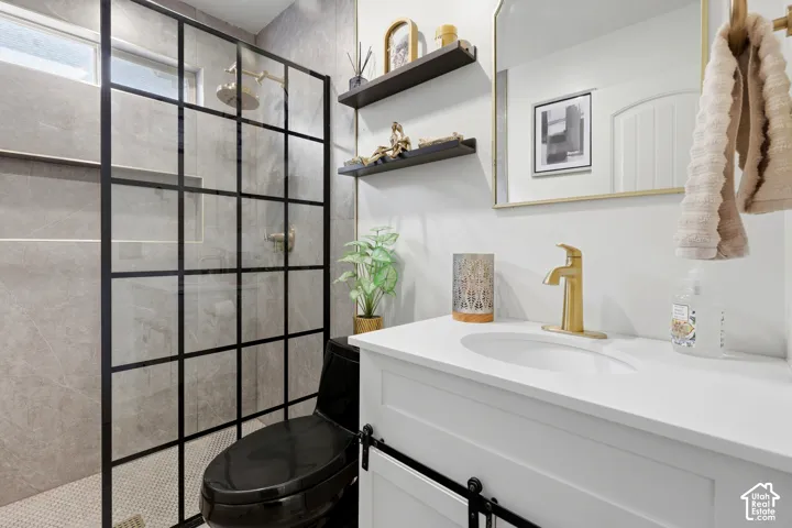 Walk-in shower with grid-patterned glass enclosure, floor-to-ceiling tile, and a black toilet