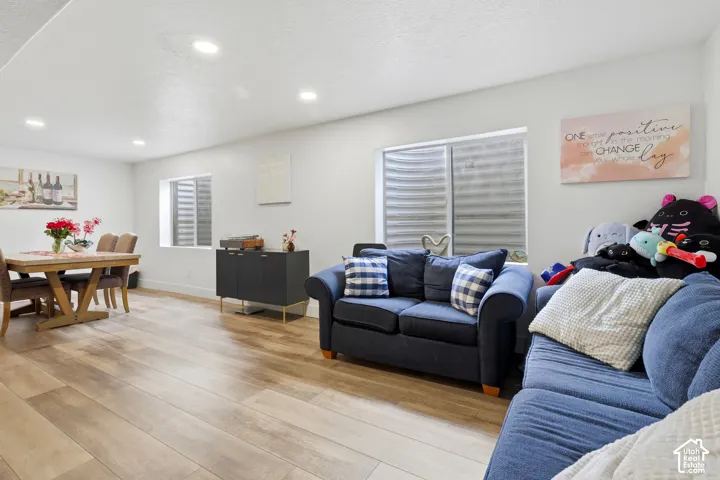 Recessed lighting, wood-finish flooring, white walls, and bright window wells