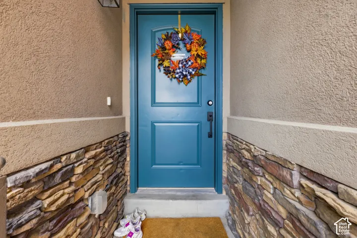 Welcoming entry featuring a striking blue paneled door with hardware detail, complemented by decorative seasonal wreath