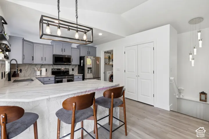 Contemporary kitchen featuring grey cabinetry, white countertops, and a full-height white backsplash