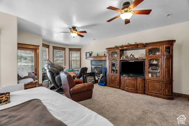 Recessed fireplace with a mantel, multiple ceiling fans, and a built-in media center