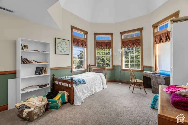 Bay window configuration with wood-trimmed windows, wall-to-wall carpeting, and a built-in shelf