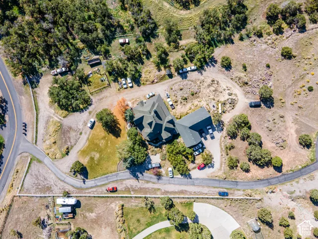 Expansive property with a multi-gabled main residence, mature trees, and a paved driveway system