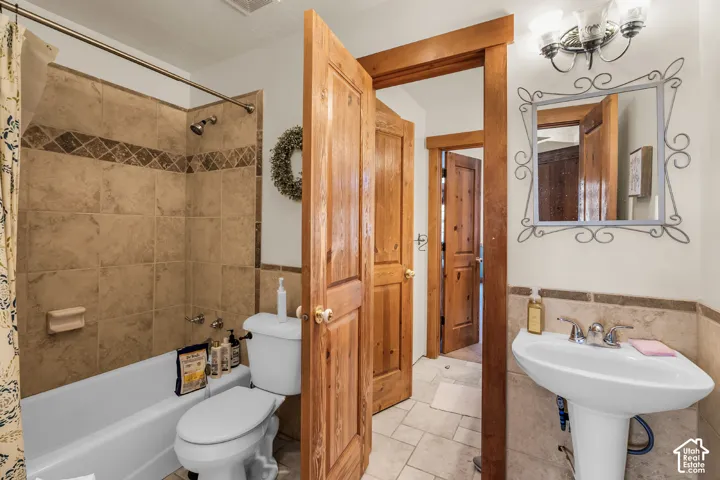 Pedestal sink with chrome faucet, framed vanity mirror, and three-light vanity fixture