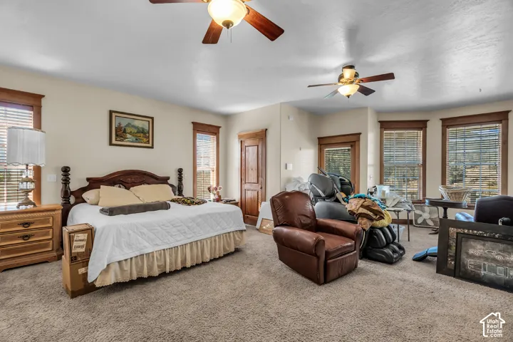 Recessed lighting with two ceiling fans, multiple windows with natural light, and a built-in wooden door