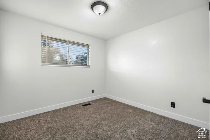 Window with horizontal blinds, flush mount ceiling light fixture, wall-to-wall carpeting, and white wall finishes
