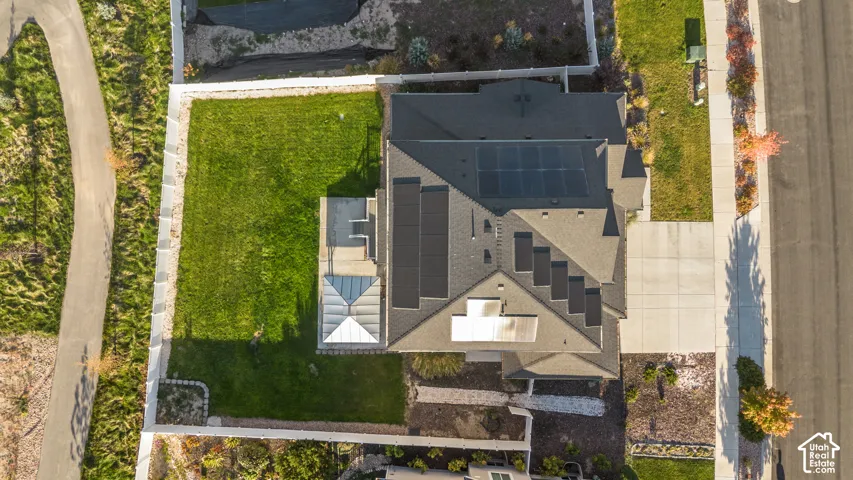 Rear yard with a manicured lawn, white fencing, and a patio area