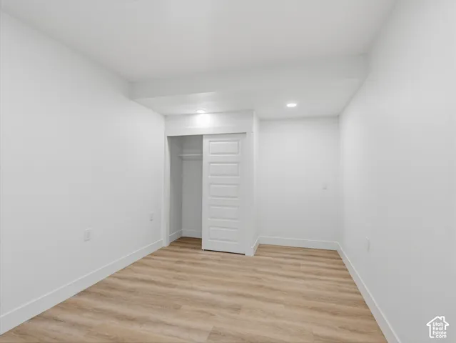 Wood-finish flooring, recessed lighting, and a white sliding closet door