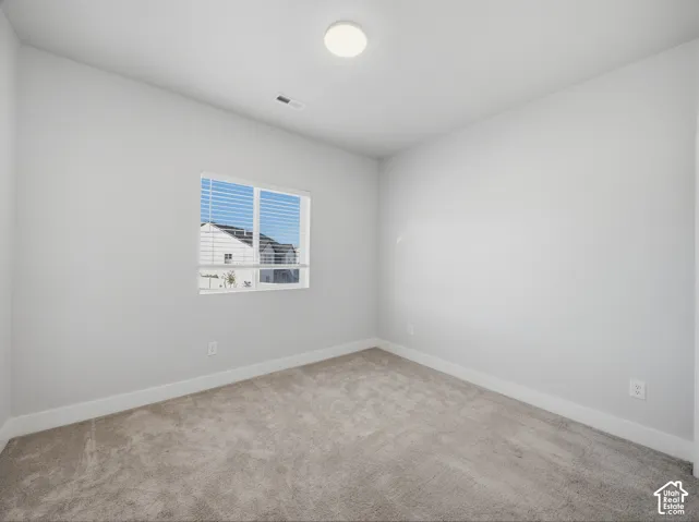 Neutral tone wall finishes, gray carpeting, and a flush mount ceiling light fixture