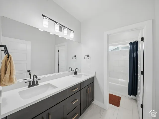 Dual vanity with undermount sinks, white countertop, dark wood-finish cabinetry, and matte black fixtures